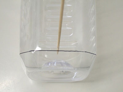 ペットボトル短辺の中央で、切り取り線から10～15mm程度離れた所に印をつけ、穴をあける。