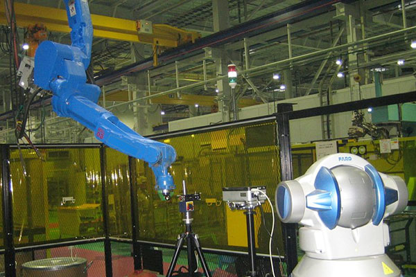 図3:レーザトラッカと、レーザ干渉計と呼ばれる測定器を使って、産業用ロボットの運動精度を測定しています。