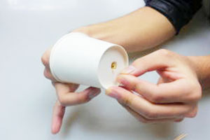 紙コップの内側から、そこの穴を通して、輪ゴムを引っ張り出します。